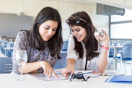 Group of happy students preparing their exams or simply relaxing at a bar