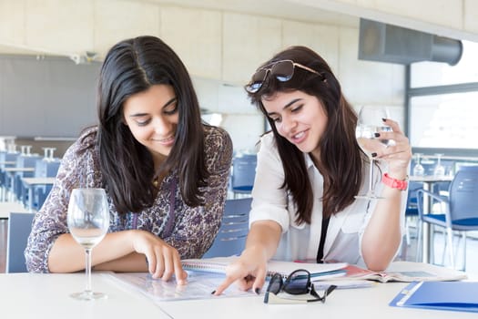 Group of happy students preparing their exams or simply relaxing at a bar