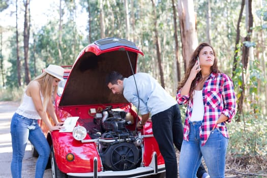 Friends on a roadtrip having a problem with their old car