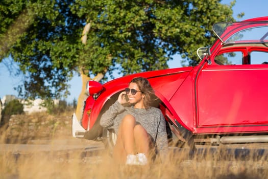 Young woman resting at car trip by the countryside
