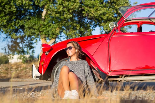 Young woman resting at car trip by the countryside