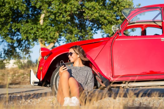 Young woman resting at car trip by the countryside