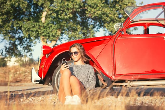 Young woman resting at car trip by the countryside