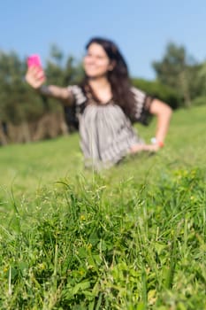 A beautiful young woman relaxing at the city park - Selective focus on the grass