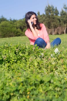 A beautiful young woman relaxing at the city park - Selective focus on the grass