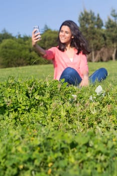 A beautiful young woman relaxing at the city park - Selective focus on the grass