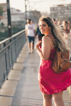Young woman tourist enjoying beautiful landscape view on the old town with river and famous iron bridge during the sunset in Porto city, Portugal