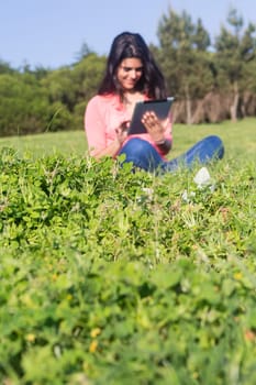 A beautiful young woman relaxing at the city park - Selective focus on the grass