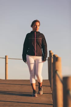 Young beautiful chinese woman exercising at the beach at sunrise/sunset