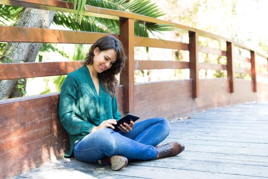 Young woman relaxing at the park with a tablet computer