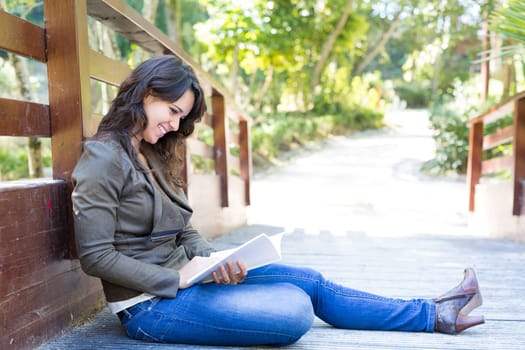 Young woman reading a book and relaxing at the park
