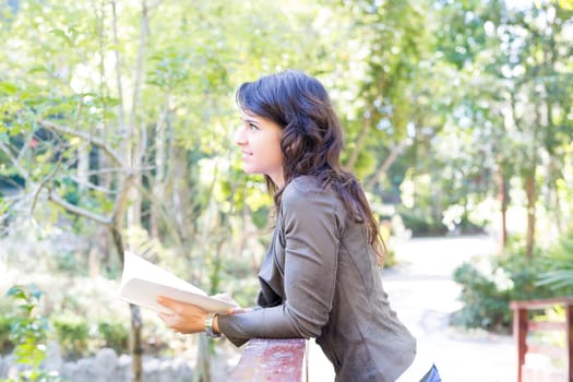 Young woman reading a book and relaxing at the park