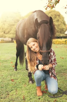 Beautiful and natural young woman spending sometime with her horse