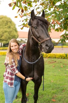 Beautiful and natural young woman spending sometime with her horse