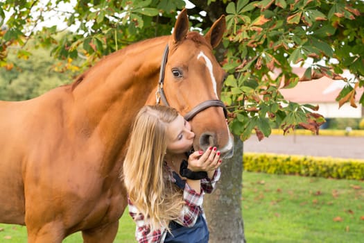 Beautiful and natural young woman spending sometime with her horse