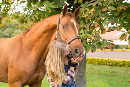 Beautiful and natural young woman spending sometime with her horse