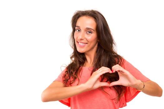 Beautiful woman making a heart shape with her hands, isolated over white background