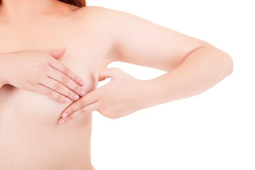 Young Caucasian adult woman examining her breast for lumps or signs of breast cancer