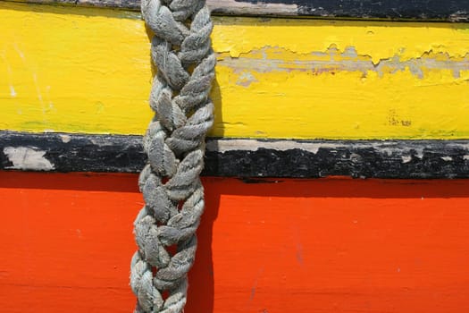 Hanging rope in a old, yellow and orange, boat