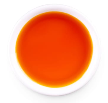 sea buckthorn oil in the white small Cup isolated on white background