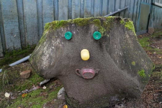 tree stump forest spirit with funny face, decorated with trinkets