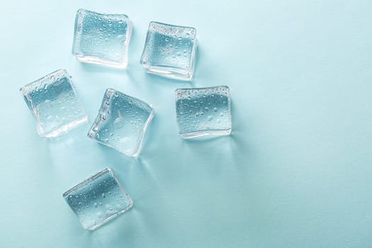 Ice cubes on vibrant light blue colors. Concept art. Minimal surrealism. Flat lay with copy space. Soft focus.