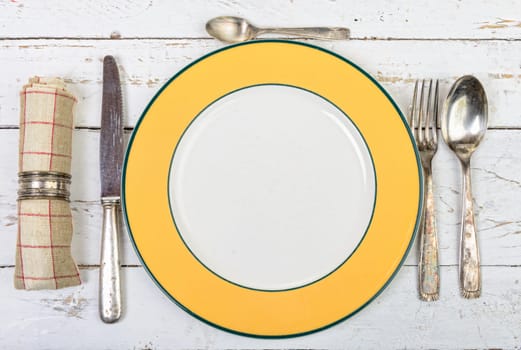 plate with silver cutlery on an old white table