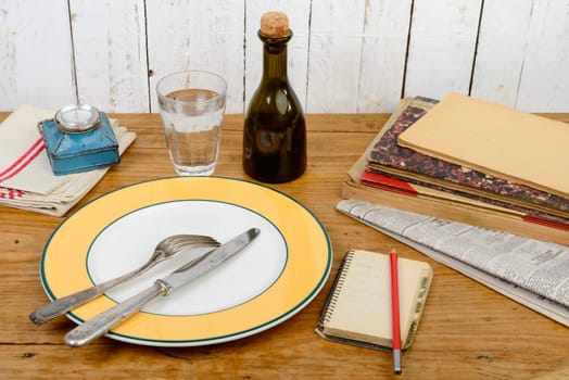plate and cutlery on an old wooden table with pencil