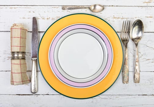plate with silver cutlery on an old white table