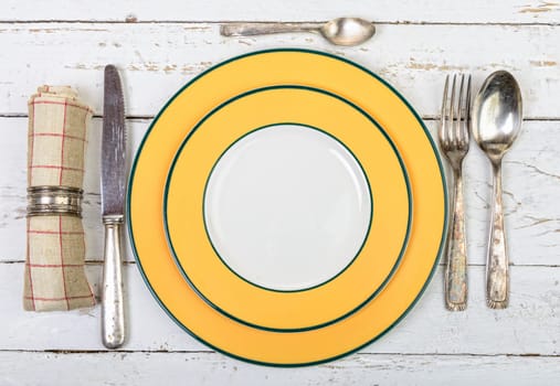 plate with silver cutlery on an old white table