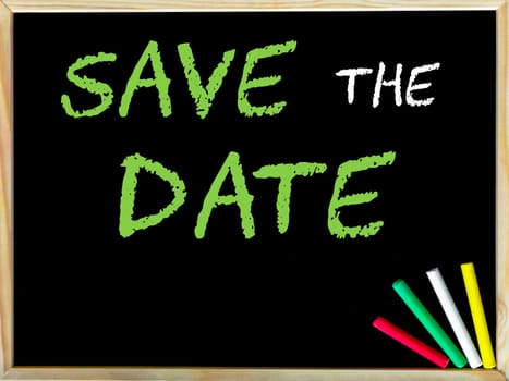 Save the date message.Handwriting with chalk on wooden frame blackboard, colored chalk in the corner. Concept image