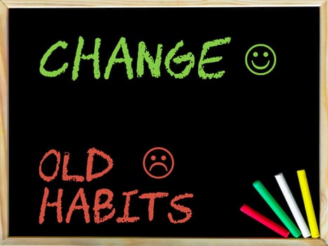 Change Old Habits message with sad and happy emoticon faces.Handwriting with chalk on wooden frame blackboard, colored chalk in the corner. Lifestyle change concept image