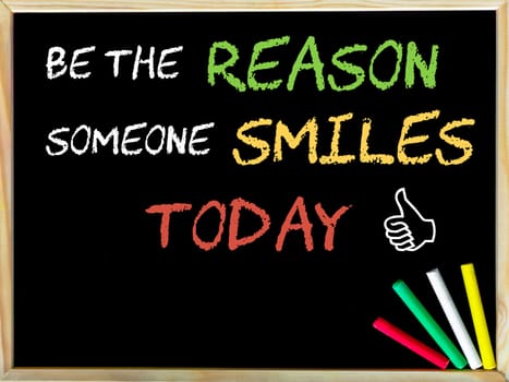 Be the reason someone smiles today message and Like sign.Handwriting with chalk on wooden frame blackboard, colored chalk in the corner, Serenity concept image
