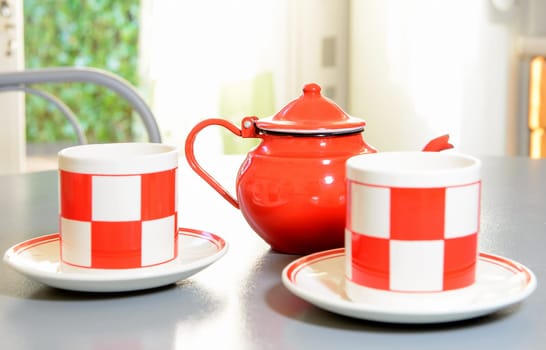 teapot and tea cups on a table painted in gray