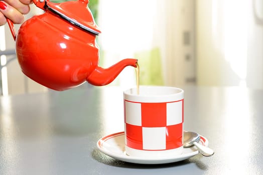 teapot and cup of tea on a table painted in gray