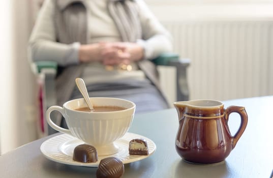 cup of hot chocolate with several sweets on a grey table