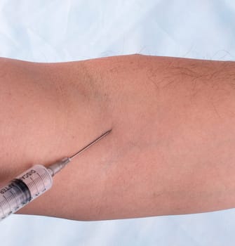 the vaccine injection in hand of man