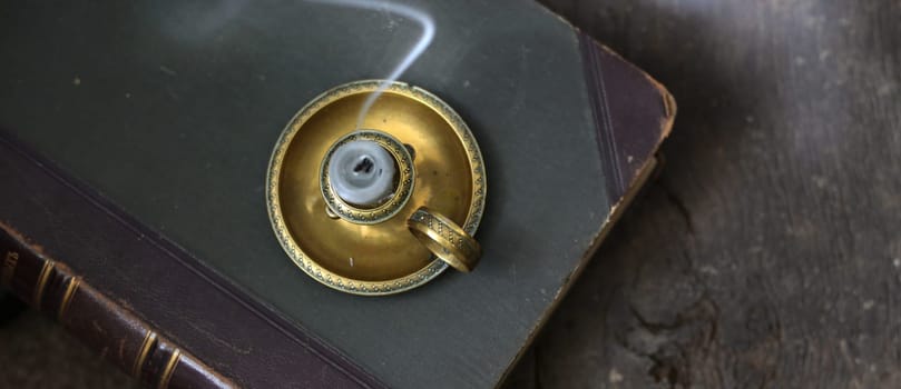 Old antique book, candle holder on old wood background. Memory, past, family album concept