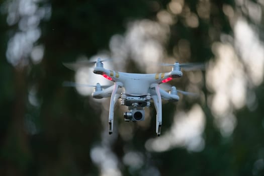 3 - Front view of a quadcopter photography drone with bokeh background. Blurred background due to selective focus, airborne technology