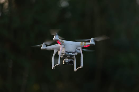 8 - UAV drone copter flying, isolated against plain background. Modern technology in action, used for videography and photography.