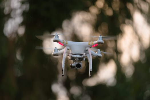 2 - Quad rotor drone hovering mid air for videography or photography. Commercially available remote control aircraft with gimbal stabilisation