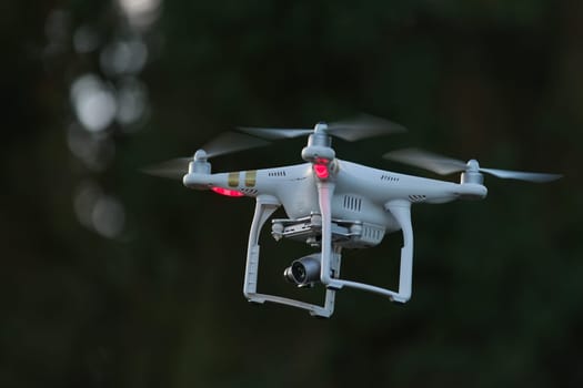 19 - UAV remote controlled commercial quad copter drone hovering. Hobby aircraft with professional imaging applications.
