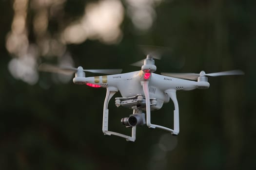 13 - Propellers spinning as this quadcopter drone hovers with camera payload. First person view flying capable, with cinematic videography usage.