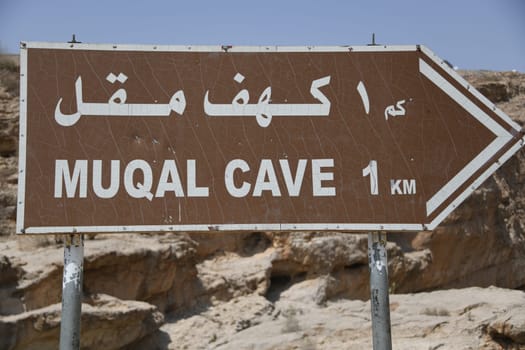 Sign which leads to the Muqal Caves in the famous Wadi Bani Khalid. It is located in the Shamal ash Sharqiyya district in the Hajar Mountains. The oasis is in the Sultanate of Oman.