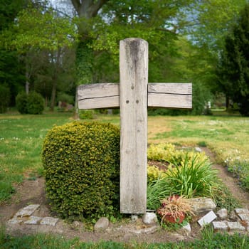 Cross made of wood on a grave in the cemetery