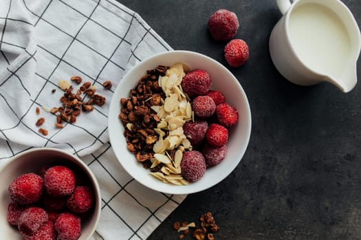 Frozen strawberry with granola, almond flakes, cream on concrete table. High quality photo