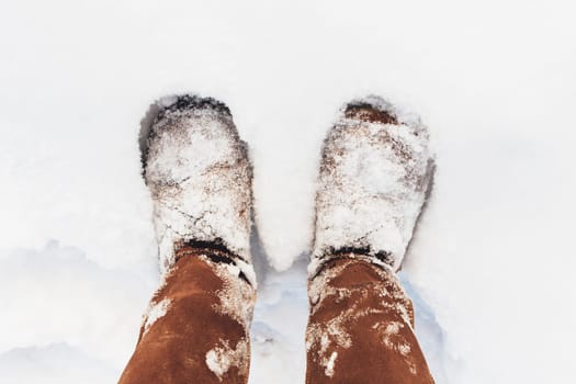 Brown boots covered with snow in the winter. High quality photo