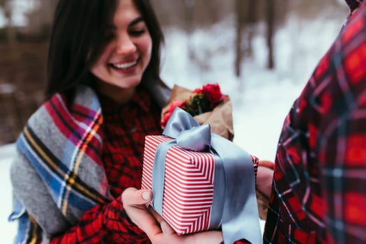 Hands giving a gift box with ribbon. Blurred background. High quality photo