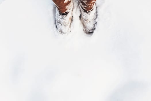 Brown boots covered with snow in the winter. High quality photo