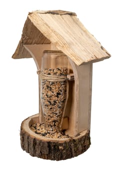 Self-made wooden bird feeder with glass bottle and bird seed i